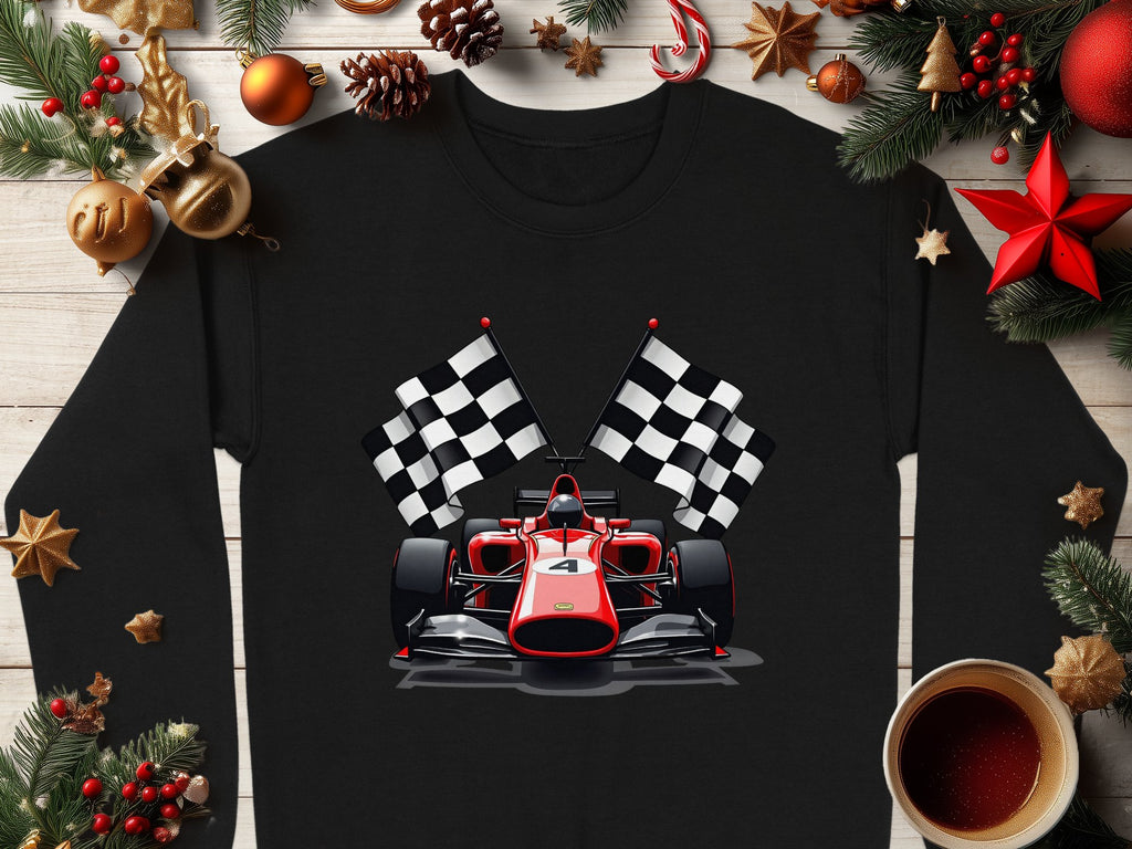 Garment Graphics presents a black long-sleeve shirt for motorsport fans, featuring a red and white racing car and two checkered flags, set amid festive pine branches, ornaments, and a coffee cup on a wooden surface.