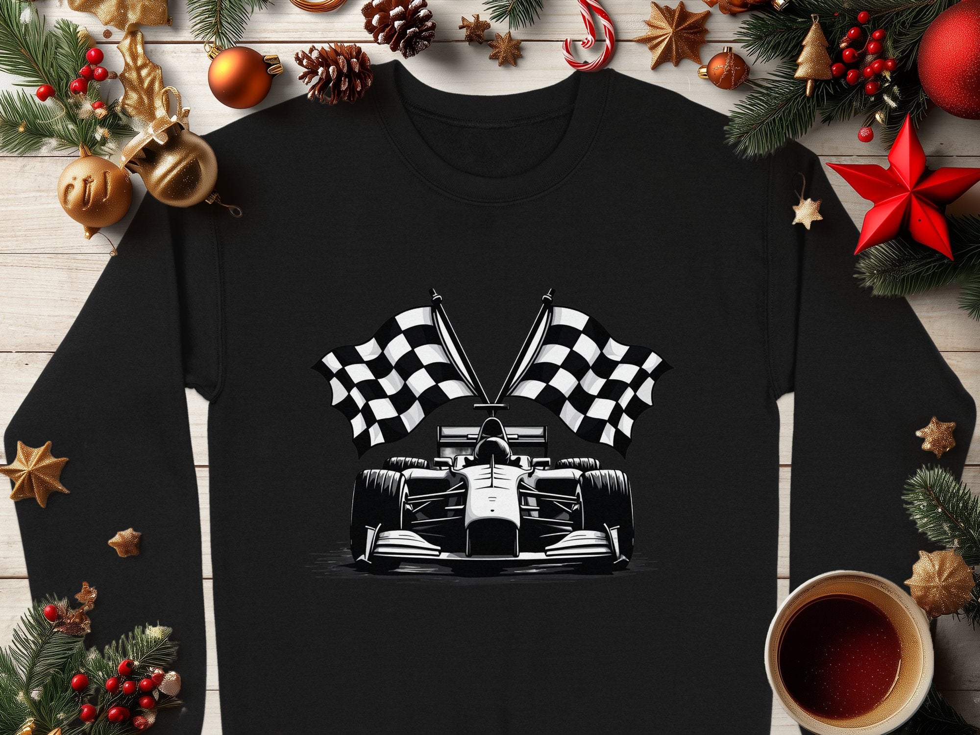 Garment Graphics offers a black shirt showcasing a striking white racing car illustration with crossed checkered flags, surrounded by festive decor like pine branches, pinecones, ornaments, and a coffee cup on wood.