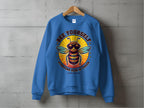 Garment Graphics Summer Edition sweatshirt features a cartoon bee wearing sunglasses in a bright yellow circle, with the phrase BEE YOURSELF EVERYONE ELSE IS TAKEN on the front. It comes in unisex sizing for a perfect fit for everyone.