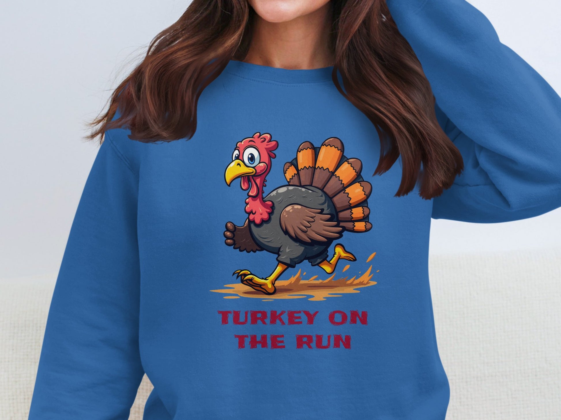 A person wearing a Garment Graphics unisex blue sweatshirt with a funny cartoon turkey running design and TURKEY ON THE RUN text, perfect for adding humor to their wardrobe.