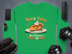 The Garment Graphics pie graphic sweatshirt in vibrant green features a playful illustration of a smiling pie slice with cream, alongside the phrases Hot & Spicy and You Wanna a Piece of Me? Its accompanied by essentials like a smartphone, smartwatch, black shoes, weights, and a speaker.