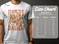 A Howdy Rodeo T-shirt from Garment Graphics, featuring a cowboy on a horse and designed for enthusiasts, is shown alongside the Gildan 5000 heavy cotton size chart detailing sizes S to 5XL with their width and length in inches.