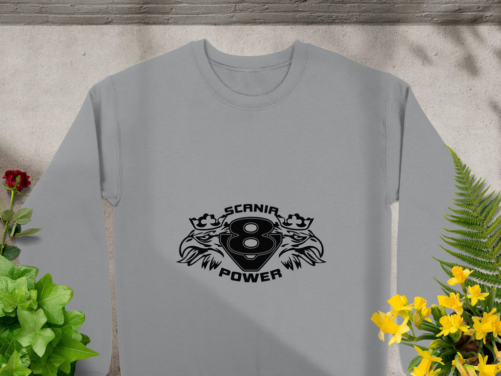 The Garment Graphics gray sweatshirt showcases the bold Scanir Power black emblem and number 8, framed by eagle heads. Its artistically surrounded by green plants, a red flower on the left, and yellow flowers on the right.