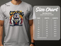 A person wears a gray Garment Graphics City King T-Shirt with a bulldog design, collar, and CITY KING text. A nearby size chart for the Gildan 5000 Heavy Cotton T-Shirt lists sizes S-5XL with measurements in inches.