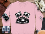 Garment Graphics pink sweatshirt features a racing car with two crossed checkered flags, surrounded by a camera, binoculars, leather gloves, a belt, and sunglasses.