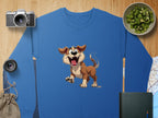 A blue sweatshirt with an animated happy dog from Garment Graphics is on a wooden surface, surrounded by a camera, lens, bowl of sliced kiwis, folded map, notebook, and drawstring pouch—a perfect choice for dog lovers.