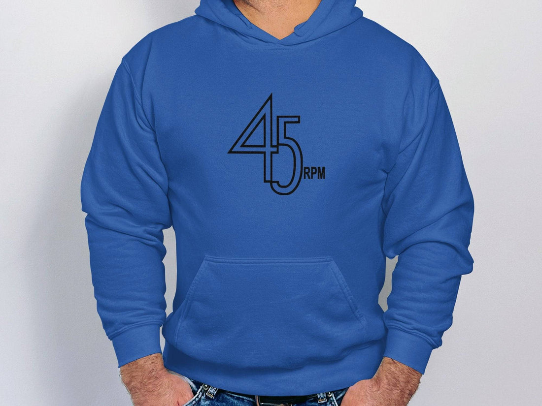 Someone is wearing a white Garment Graphics hoodie with 45 RPM on the front, ideal for vinyl enthusiasts. Standing on a street with blurred buildings behind them, they highlight their passion for graphic hoodies and vintage music.