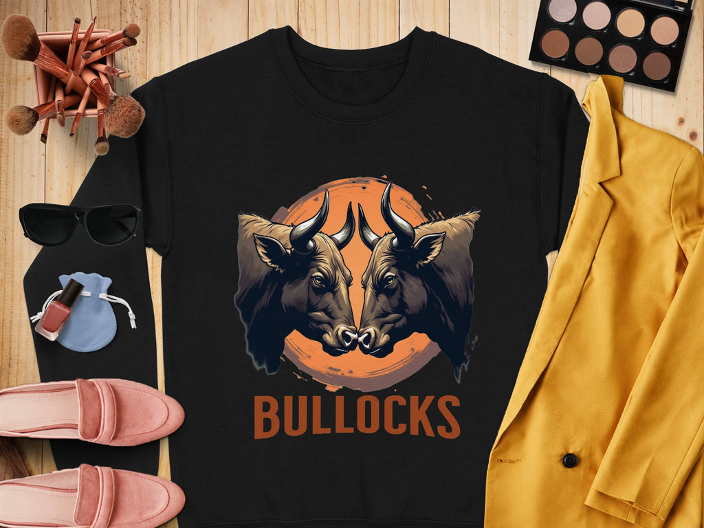 Garment Graphics presents an eye-catching black sweatshirt with a striking bullocks graphic print on a wooden backdrop. Pair it with a yellow jacket, pink shoes, sunglasses, makeup essentials, and a blue drawstring bag for a chic outfit.