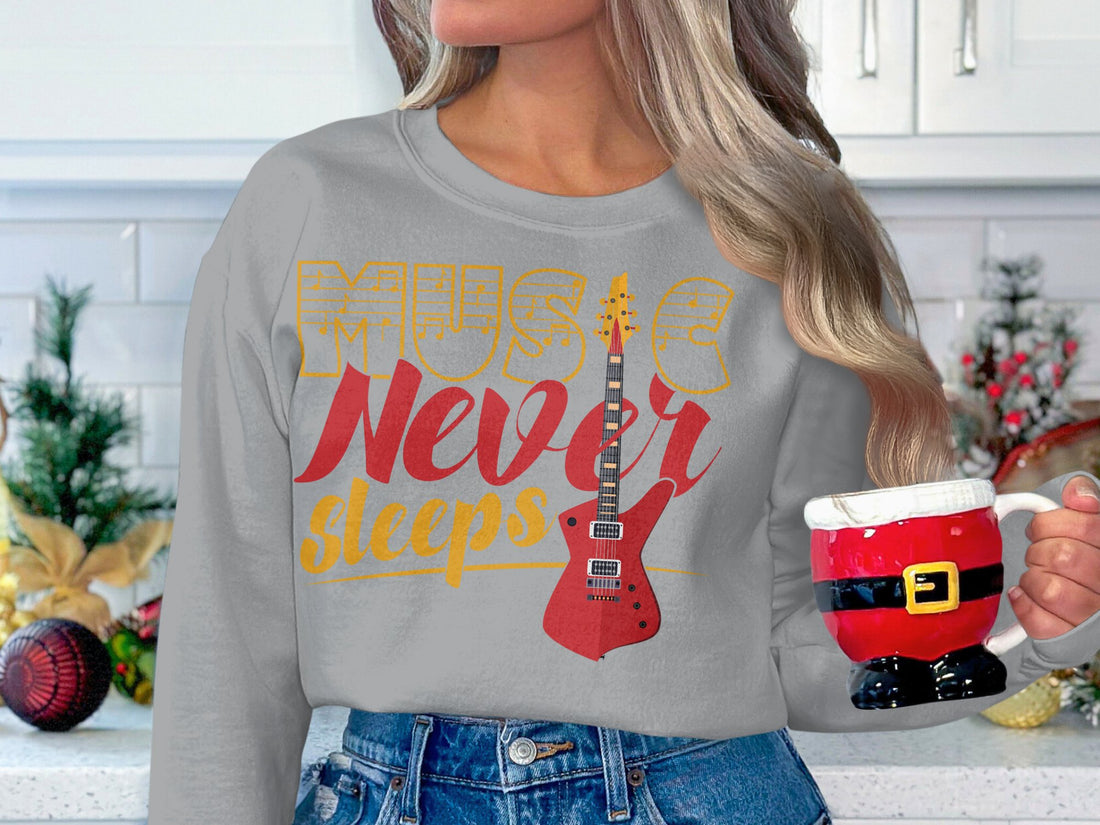 A person wears a stylish Garment Graphics sweatshirt featuring Music Never Sleeps and a red electric guitar graphic, ideal for music lovers. The background shows an outdoor setting with blurred elements.