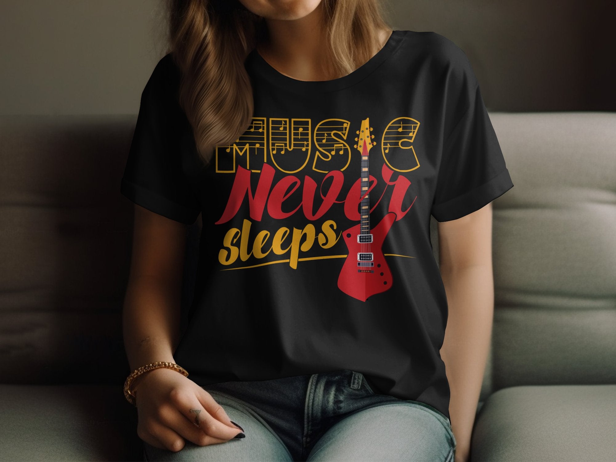 A person is seated on a couch, wearing a distinctive t-shirt by Garment Graphics. The black shirt reads Music Never Sleeps in bold, featuring a striking red electric guitar design.
