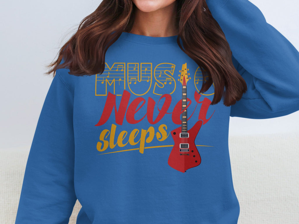 A music enthusiast proudly wears a trendy Garment Graphics sweatshirt adorned with the phrase Music Never Sleeps and an illustration of a red electric guitar.