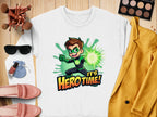Garment Graphics offers a white unisex cartoon-themed sweatshirt showcasing a superhero with brown hair and a green glowing fist, alongside the text Its Hero Time! The scene includes makeup, sunglasses, pink shoes, a yellow jacket, and a small pouch on wood.