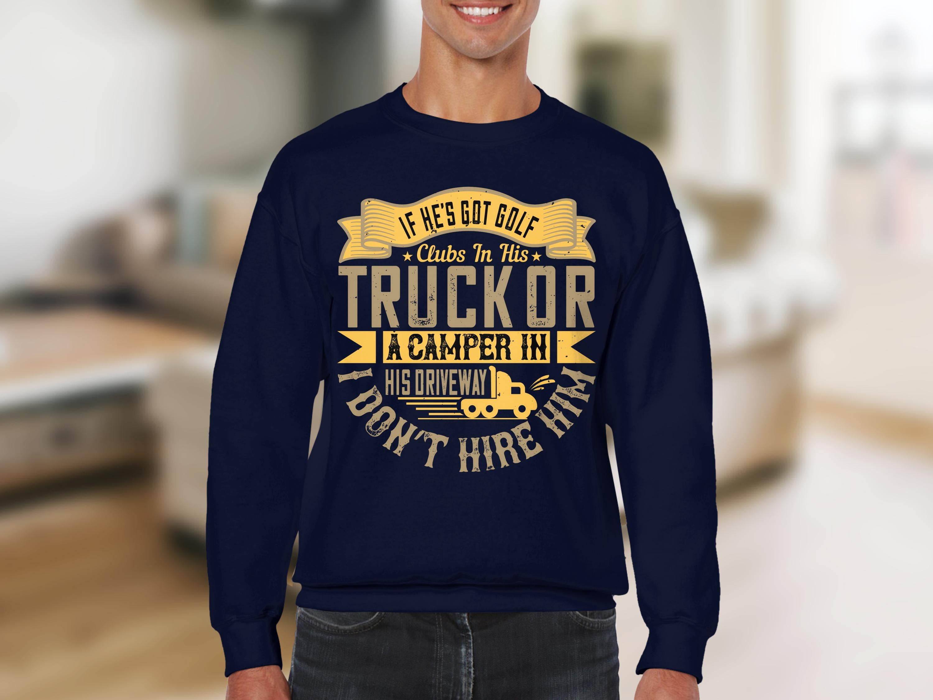 A person wearing a funny navy blue sweatshirt by Garment Graphics with gold text, If hes got golf clubs in his truck or a camper in his driveway, I dont hire him, along with decorative banners and a small truck and camper image—ideal for casual wear.
