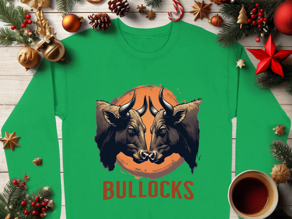 This green unisex long-sleeve shirt by Garment Graphics features two forward-facing bulls on an orange circular background, with BULLOCKS printed below amidst pine branches, ornaments, and a coffee cup on wood.