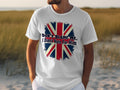 Wearing a Garment Graphics classic fit white T-shirt featuring the Union Jack and the text Dont blame me, I didnt vote for him, someone makes a bold statement. The backdrop features sandy terrain with grass patches.