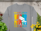 Gray sweatshirt by Garment Graphics with a vibrant DJ design over vertical yellow, red, green, and blue stripes. Features retro Dont Stop the Music text above and below the colorful DJ graphic using turntables. Surrounded by plants, it’s perfect for music lovers.