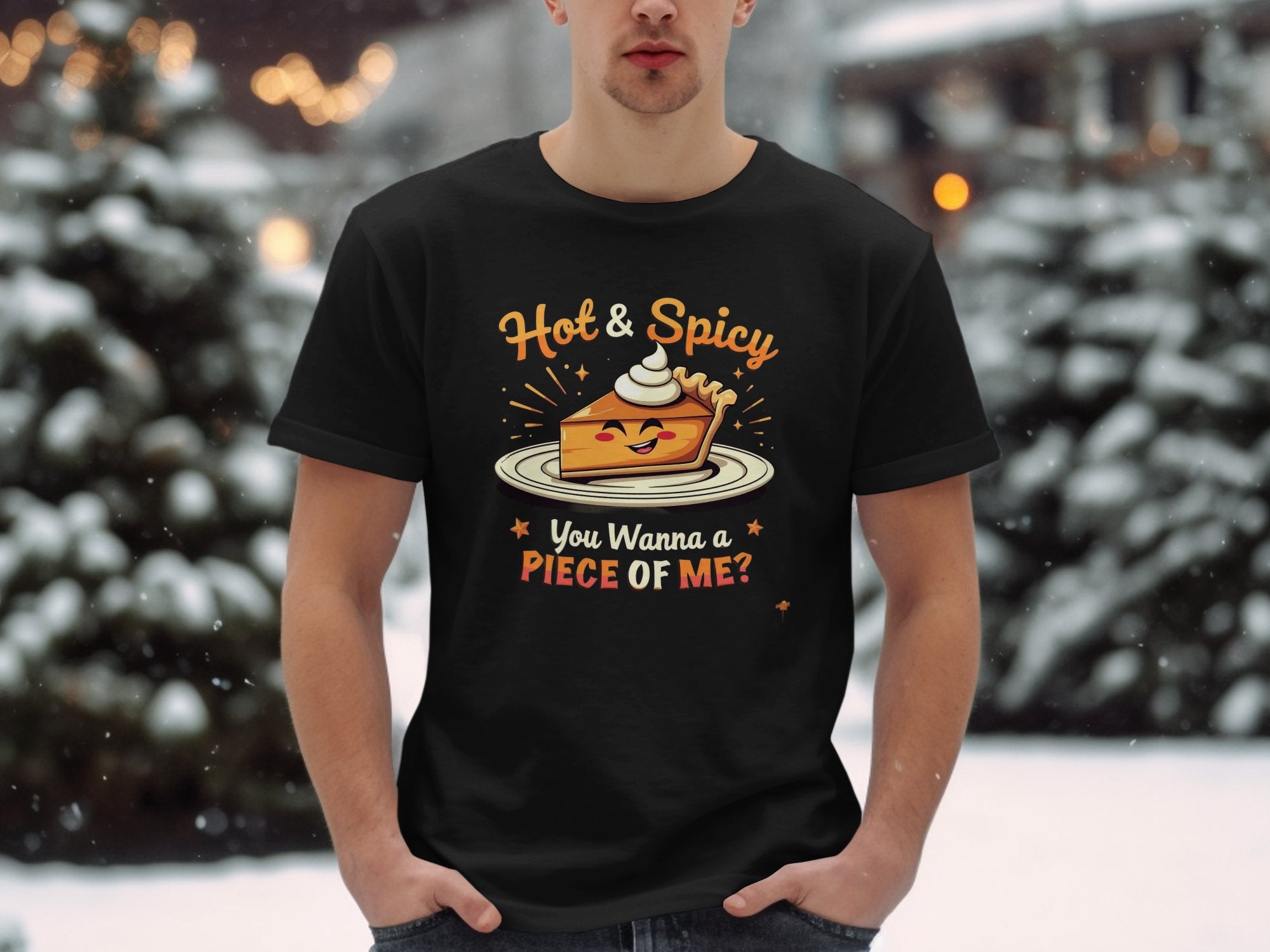 In a snowy setting, someone wears a black Garment Graphics t-shirt with the Hot & Spicy Pie Design, featuring a pie with whipped cream and the playful tagline, You Wanna a Piece of Me?.