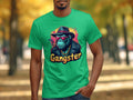 Someone is donning a classic fit green t-shirt from Garment Graphics, featuring a chimpanzee with a hat, sunglasses, and necklace labeled Gangster. This urban style complements the tree-lined path in the background with scattered leaves.