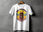 A white T-shirt by Garment Graphics hangs on a wooden hanger against a gray backdrop, featuring a bee with sunglasses. The text Every One Else Is Taken, Summer Edition circles an orange background. This shirt offers family sizing for everyone to showcase their unique style together.