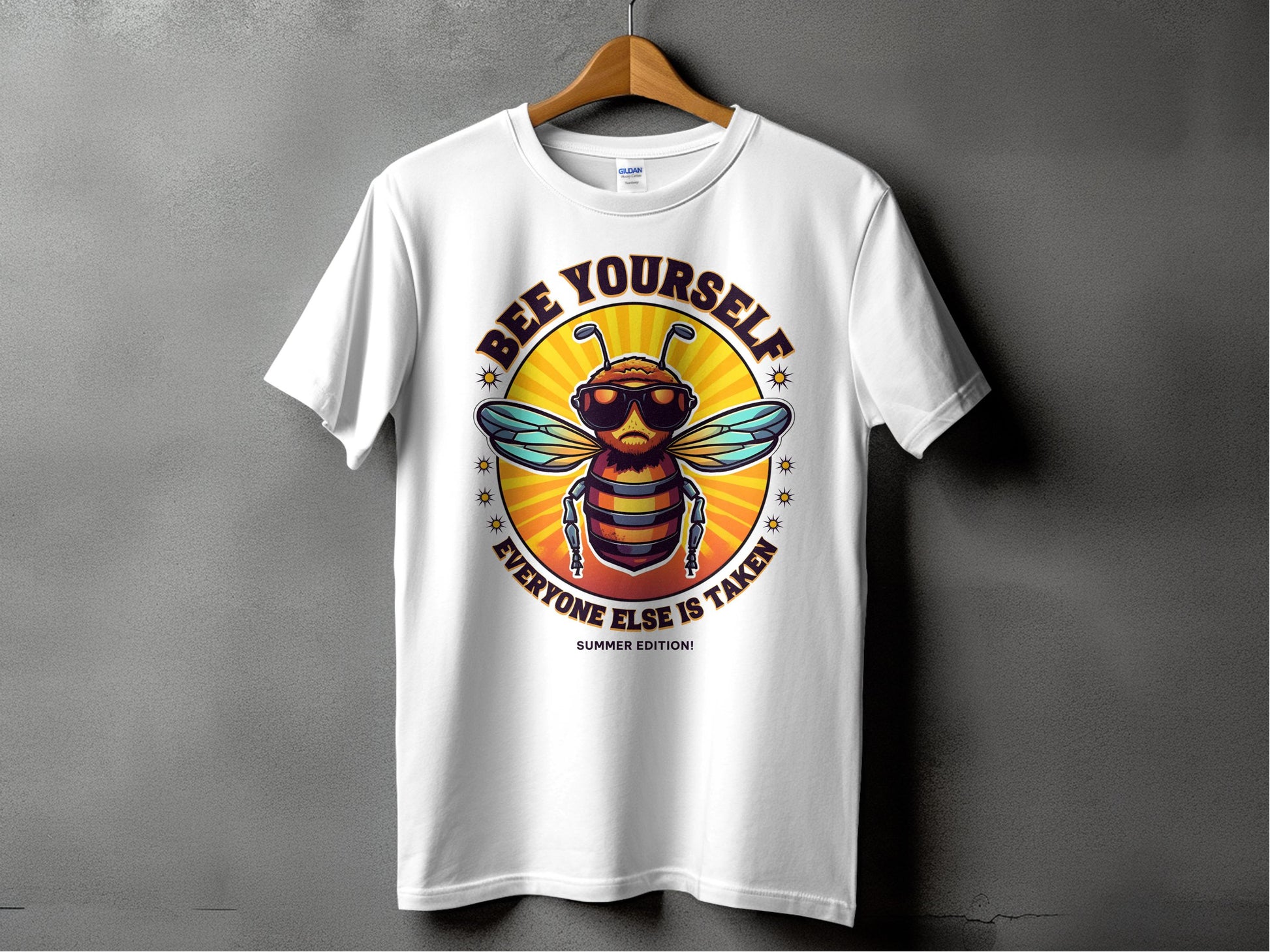 A white T-shirt by Garment Graphics hangs on a wooden hanger against a gray backdrop, featuring a bee with sunglasses. The text Every One Else Is Taken, Summer Edition circles an orange background. This shirt offers family sizing for everyone to showcase their unique style together.