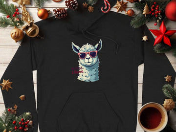 Garment Graphics classic fit black hoodie features a cartoon llama in funny sunglasses and Llamas printed. Its adorned with festive decorations: pinecones, red stars, cinnamon sticks, and a cozy hot drink on a wooden surface.