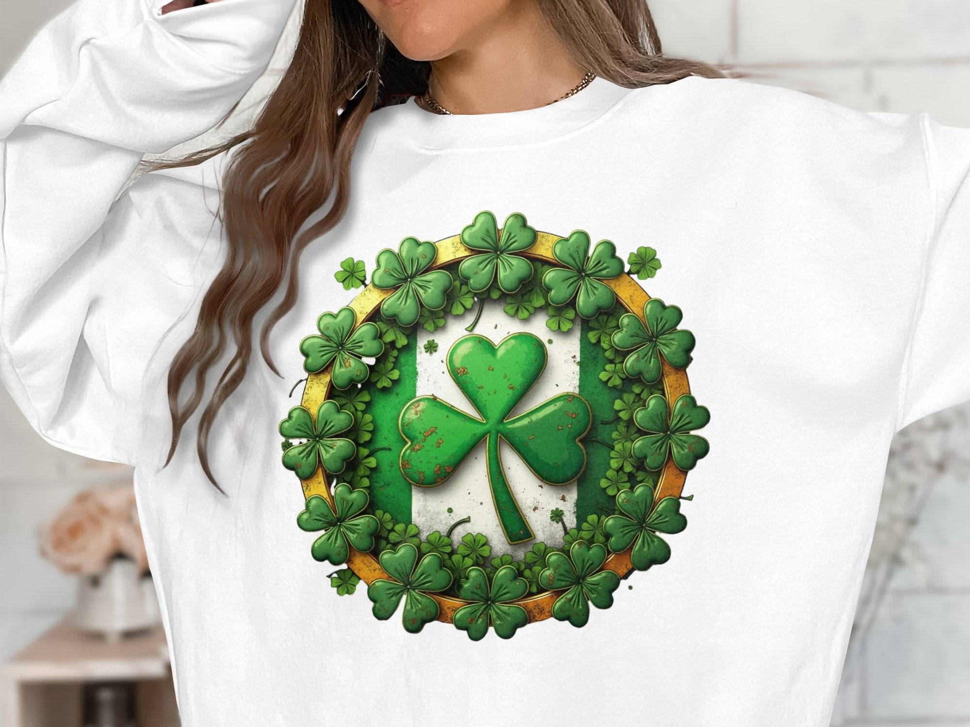 A person wears a Garment Graphics white sweatshirt showcasing Irish spirit with a large green shamrock encircled by smaller ones, capturing the essence of Circle Design Sweatshirts. The textured design contrasts perfectly against the neutral backdrop, though their face remains unseen.