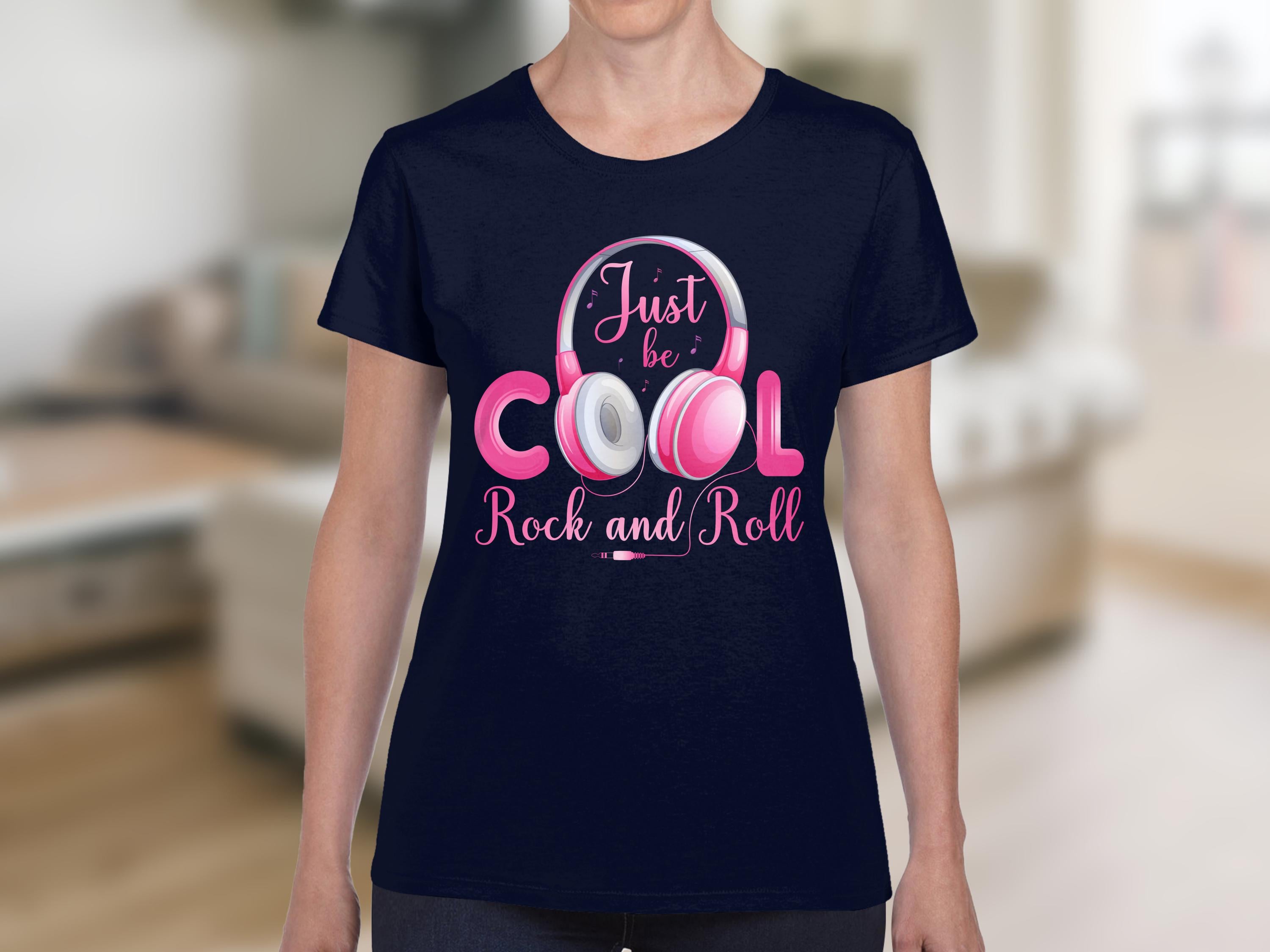 A music lover wears a Garment Graphics navy blue t-shirt showcasing a pink and white headphone design. The shirt, featuring Just be COOL Rock and Roll, epitomizes rock spirit, with an indoor background of blurred furniture enhancing the vibe.