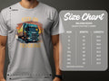 A person wears a gray Garment Graphics t-shirt with a large truck and the bold orange text Keep on Trucking, perfect for truck fans. Next to it is the size chart for the Gildan 5000 heavy cotton t-shirt, showing sizes S to 5XL with width and length measurements.