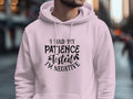 Wearing a classic fit Patience Tested Hoodie by Garment Graphics, featuring the phrase I had my patience tested, I’m negative, a person strides through an urban landscape as tall buildings and a bustling street blur in the background.