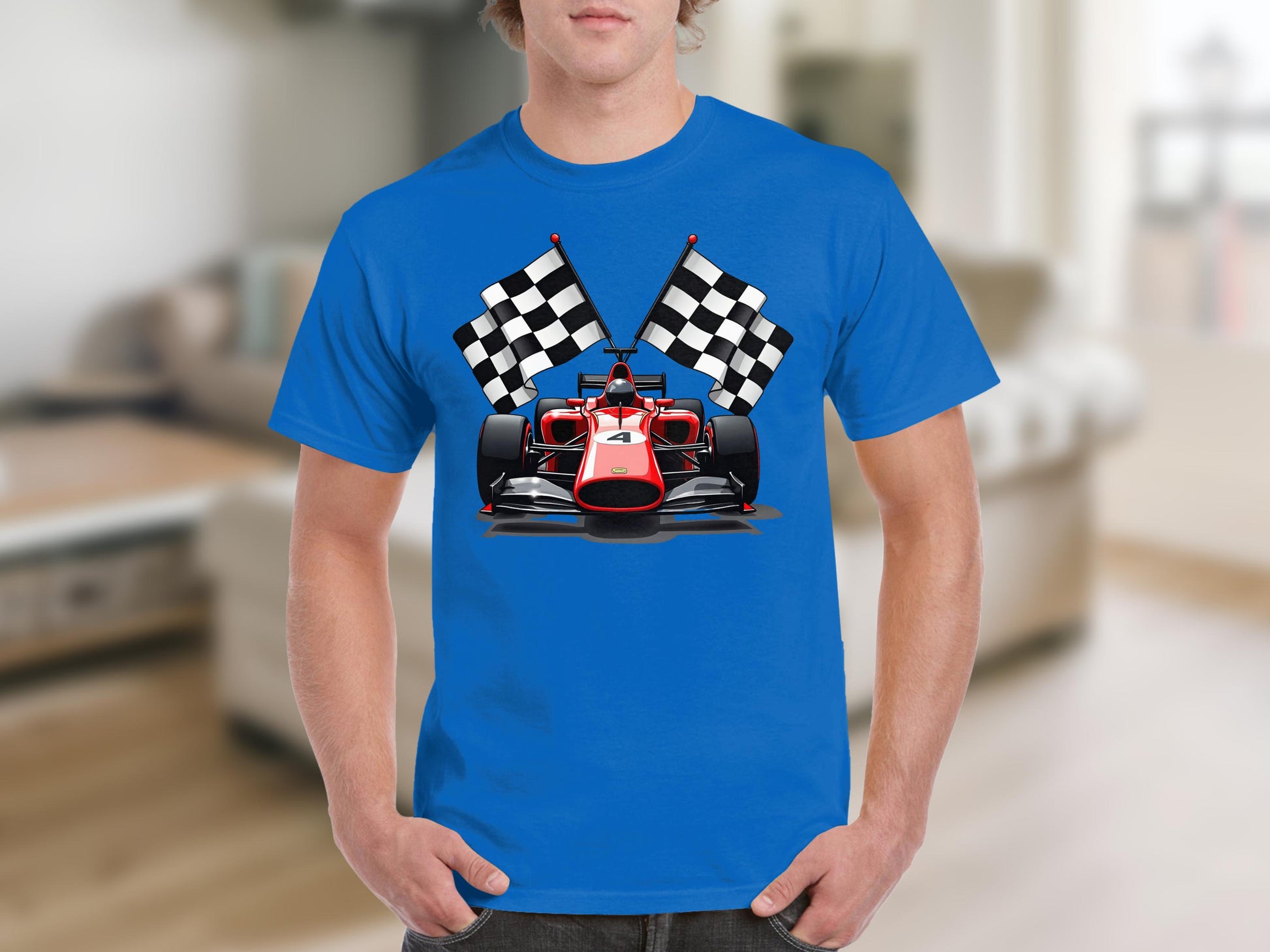 A motorsport enthusiast wears a trendy Garment Graphics T-shirt featuring a blue race car and two black and white checkered flags, set against a blurred indoor backdrop with a couch and chairs.