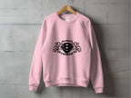 A pink sweatshirt from Garment Graphics hangs on a wooden hanger against a gray wall, featuring the Scania Power 8 logo with two lions flanking the number eight and SCANIA POWER boldly printed in black.