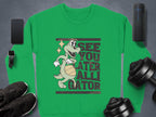 A Garment Graphics green sweatshirt showcases a fun alligator graphic and the playful text See You Later Alligator, surrounded by a smartphone, smartwatch, earphones, dumbbells, speakers, and black shoes.