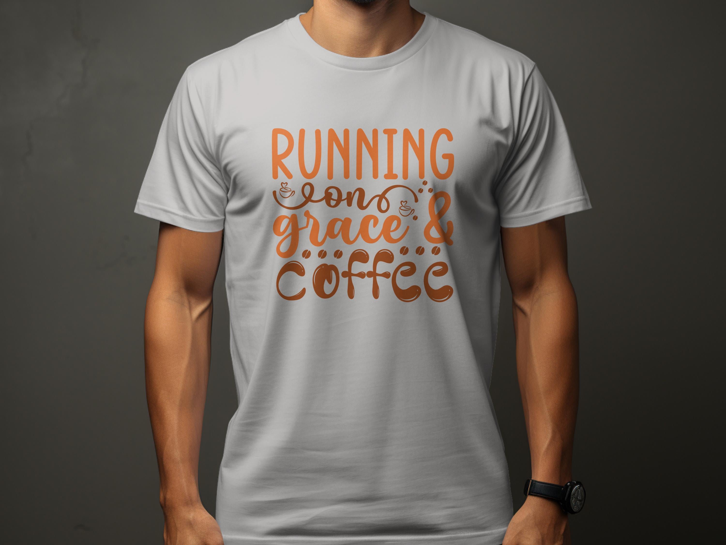 A person wears a gray Garment Graphics T-shirt featuring Running on Grace & Coffee in vibrant orange and brown. The design includes decorative swirls and coffee cup motifs on a plain dark background.