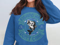 Garment Graphics offers a blue fishing sweatshirt with Fishing Hair Dont Care around a fish graphic. It features small anchors and decorative circular elements, making it perfect for any fishing enthusiast.