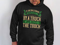 A person wearing a Garment Graphics hoodie with green and beige text saying, If an Englishman gets run down by a truck, he apologizes to the truck, perfectly captures the essence of English etiquette.
.