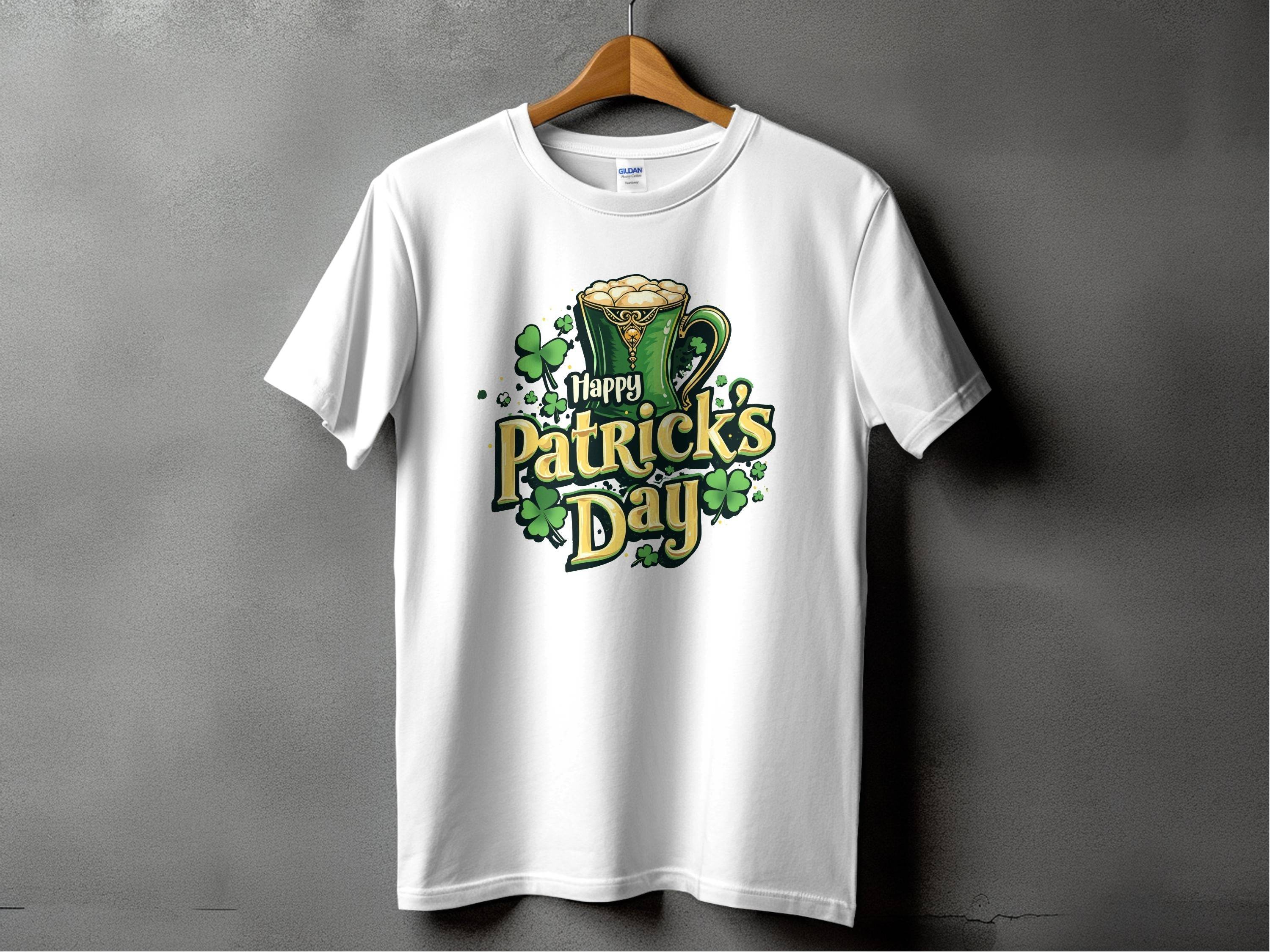 A white Happy Patricks Day T-Shirt by Garment Graphics hangs on a gray backdrop, featuring green text, a frothy beer mug, and scattered shamrocks. This lively shirt is ideal for celebrations, making it a fun way to embrace the festive spirit.