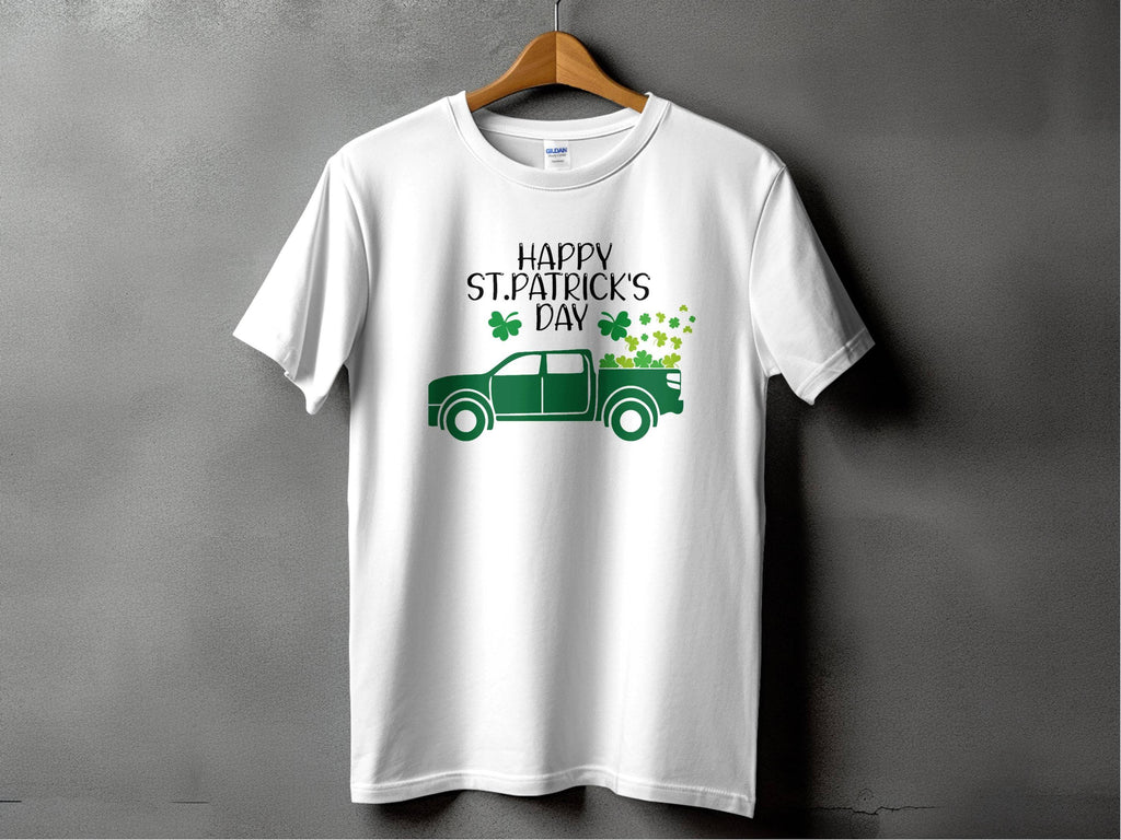 A white T-shirt by Garment Graphics displays a green pickup truck with shamrocks and the phrase Happy St. Patricks Day above it, set against a gray background, celebrating Irish pride.