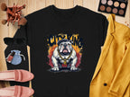 Flat lay featuring a black Garment Graphics bulldog sweatshirt with a gold chain design, surrounded by sunglasses, makeup brushes, a yellow blazer, blue pouch, pink shoes, lipsticks, and an eyeshadow palette on a wooden background.
