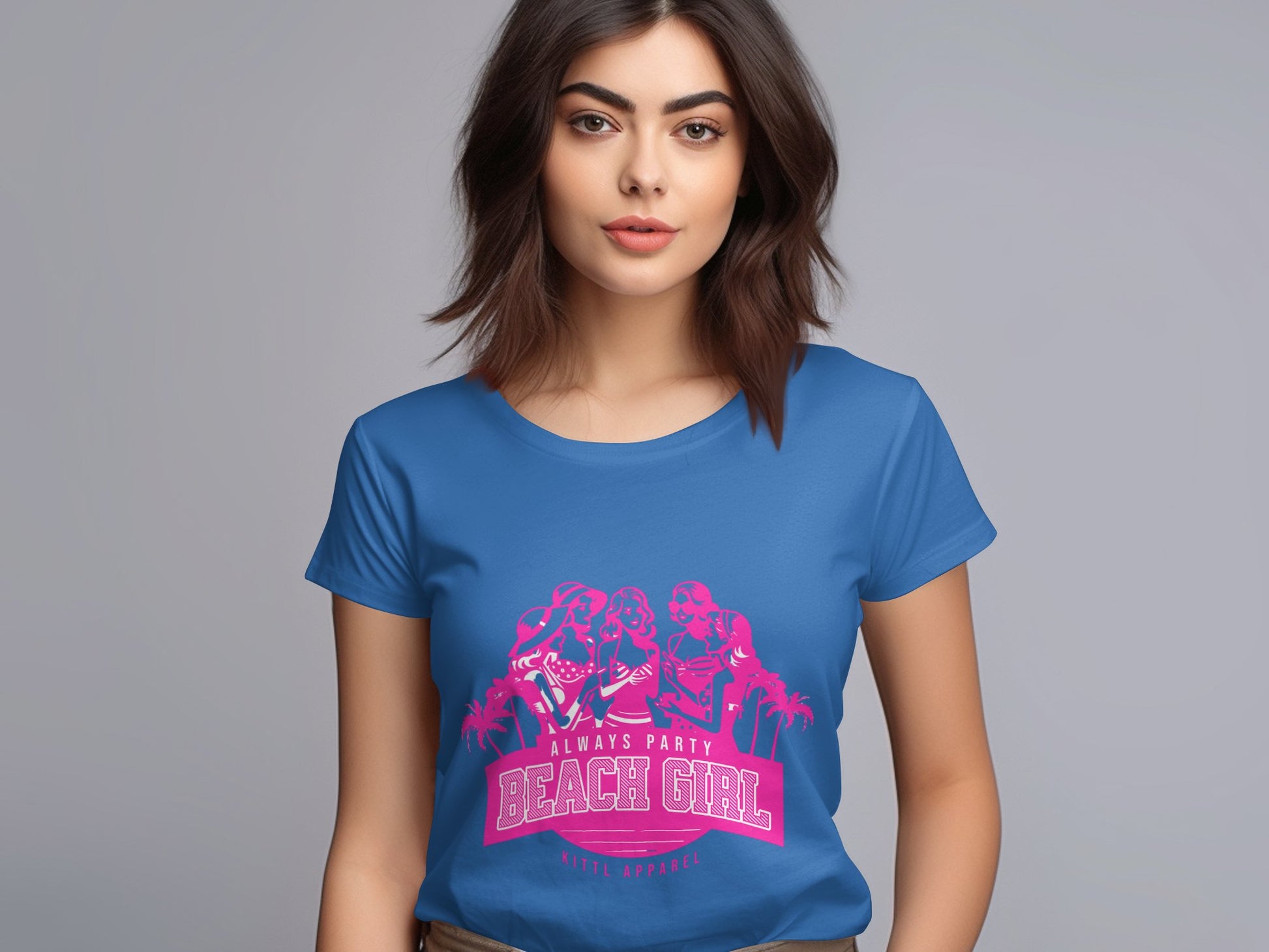A woman with shoulder-length brown hair is wearing a blue Garment Graphics T-shirt featuring a pink Always Party Beach Girl graphic, set against a gray background.
