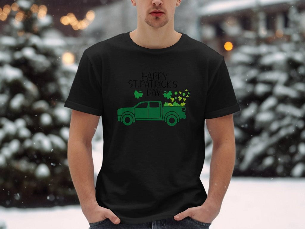 In a snowy landscape, someone wears a Garment Graphics black t-shirt boasting Irish pride with a green pickup truck and shamrocks, reading Happy St. Patricks Day in black text, framed by serene trees and snow.