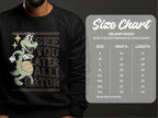 This Garment Graphics sweatshirt features a cartoon alligator with a basketball and See You Later Alligator text. It offers unisex sizing (Gildan 18000), ranging from S to 5XL, with detailed width and length measurements available in the size chart.