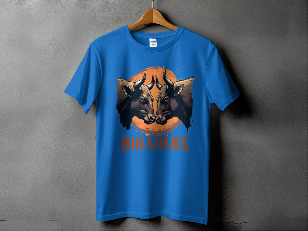A blue T-shirt from Garment Graphics Bullocks Pintable line features a bulls face graphic and BULLOCKS text, hanging against an orange background. Available in Family Sizing for a cohesive look, it offers a Classic Fit.