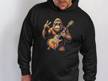 Someone is wearing a black hoodie from Garment Graphics featuring a Guitar Playing Gorilla with sunglasses and a peace sign, ideal for animal lovers and music enthusiasts.