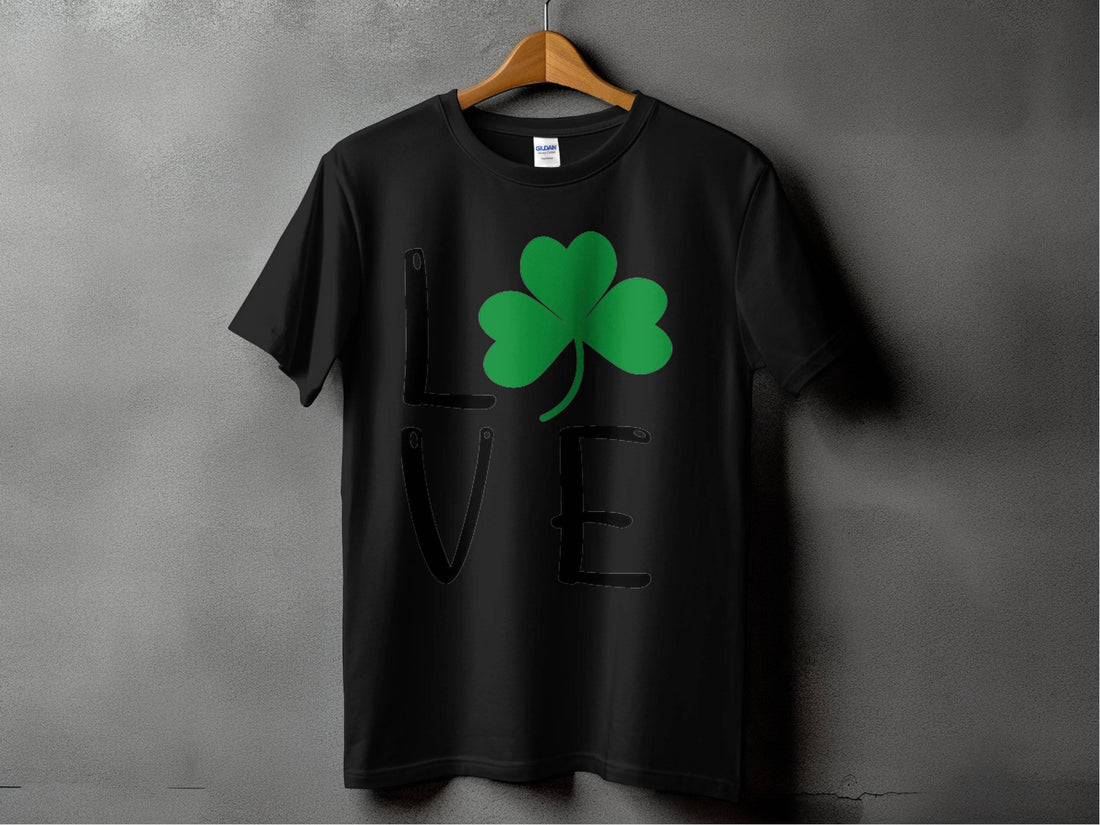 Garment Graphics presents a white T-shirt displaying the word LOVE, where a green shamrock artfully replaces the letter O, all set against a gray backdrop. This festive design is perfect for celebrating St. Patricks Day with Irish spirit and charm.