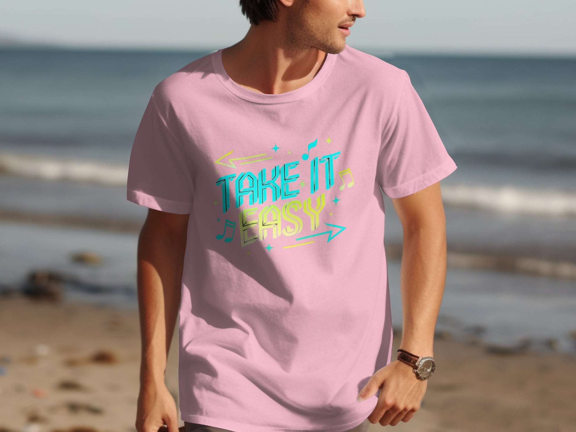 A beachgoer dons Garment Graphics pink t-shirt, adorned with vibrant designs and Take It Easy in colorful letters, strolling along the ocean-swept sandy shore.