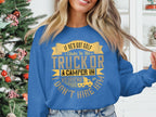 A woman wears a Garment Graphics blue sweater with the funny message: If hes got golf clubs in his truck or a camper in his driveway, I dont hire him. A decorated Christmas tree enhances the festive atmosphere, highlighting her quirky outfit.