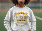 A woman showcases her unique style in a Garment Graphics white sweatshirt with the witty phrase, If hes got golf clubs in his truck or a camper in his driveway, I dont hire him, standing outdoors against a blurred backdrop.