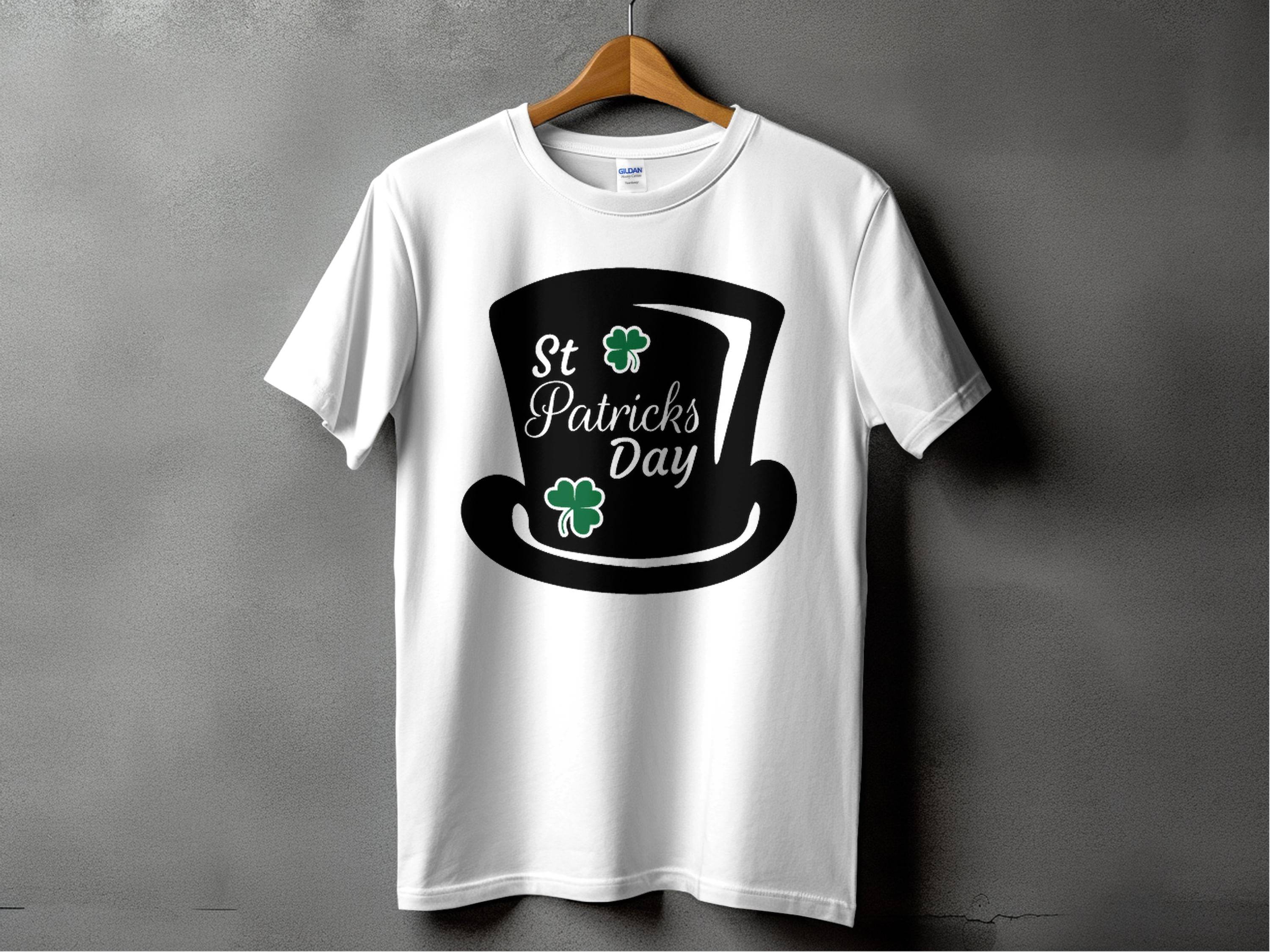 Garment Graphics white T-shirt features St. Patricks Day text, a black top hat, and two green shamrocks reminding of a four-leaf clover, against a gray background—ideal for festivities.