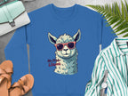 The Garment Graphics unisex blue No Prob-llama sweatshirt features a llama in red sunglasses, surrounded by sandals, a striped shirt, watch, and light blue handbag on gray—ideal for those seeking humor in their wardrobe with this whimsical top.