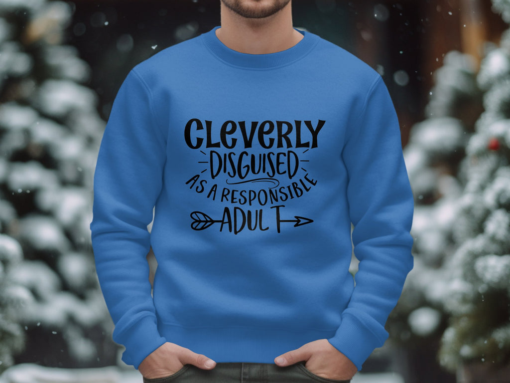 A person outdoors wears a blue Garment Graphics Cleverly Disguised as a Responsible Adult sweatshirt in unisex sizing, embodying humorous chic. Snow and blurred trees create a serene backdrop, enhancing the playful vibe of these sweatshirts.
